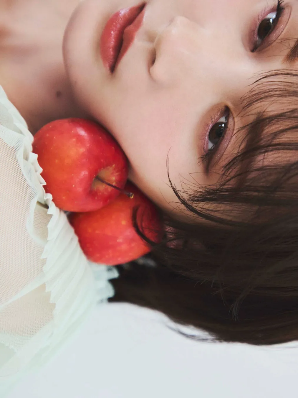 女性の顔と赤いリンゴが写った写真。