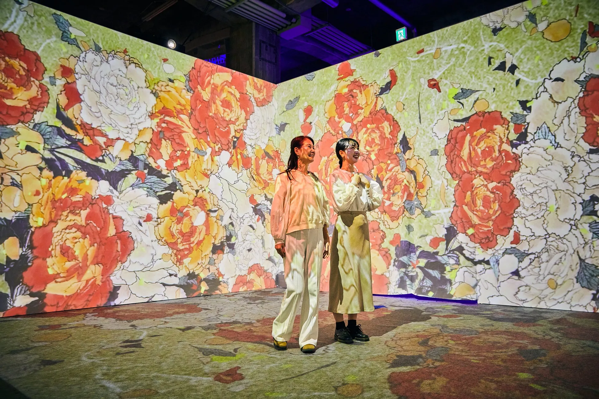 花柄のプロジェクションマッピングが施された空間に立つ女性たち