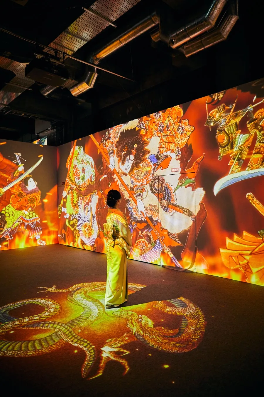 龍の絵が投影された部屋に立つ女性