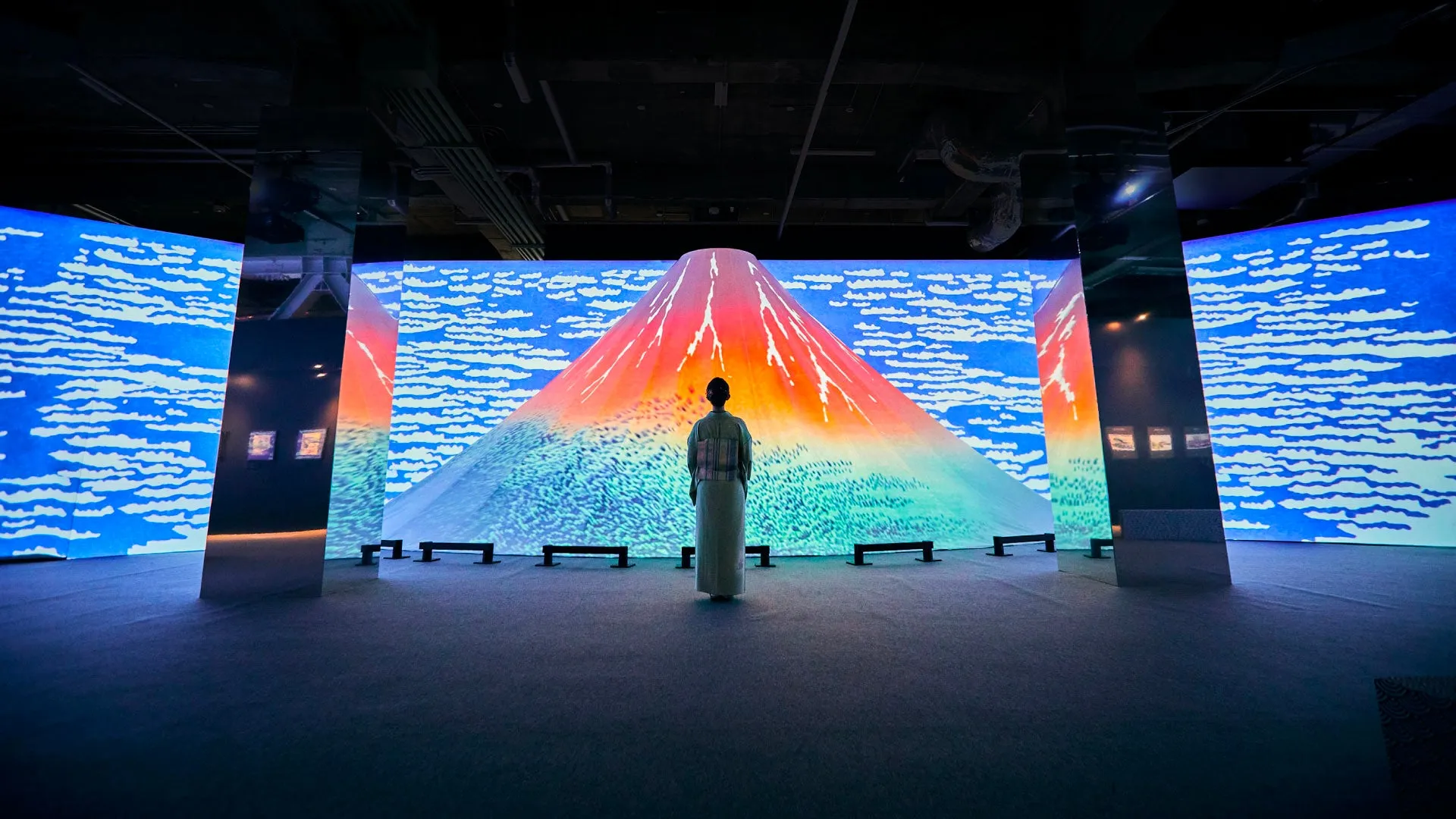 富士山をモチーフにしたデジタルアート作品の前で、着物姿の女性が鑑賞