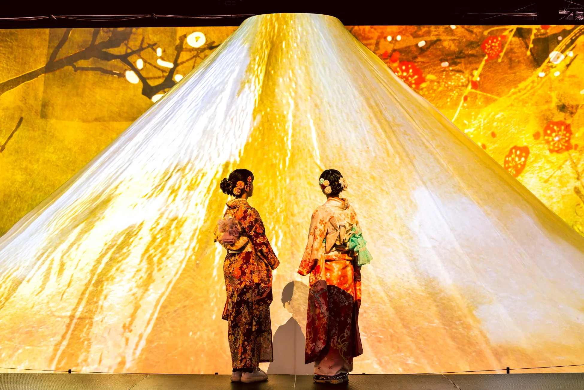 富士山のような背景の前で立つ女性たち