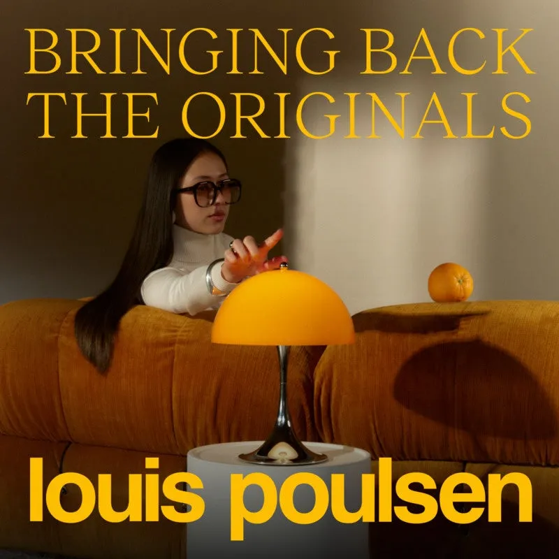 女性がオレンジ色のランプとオレンジの近くに座っている写真