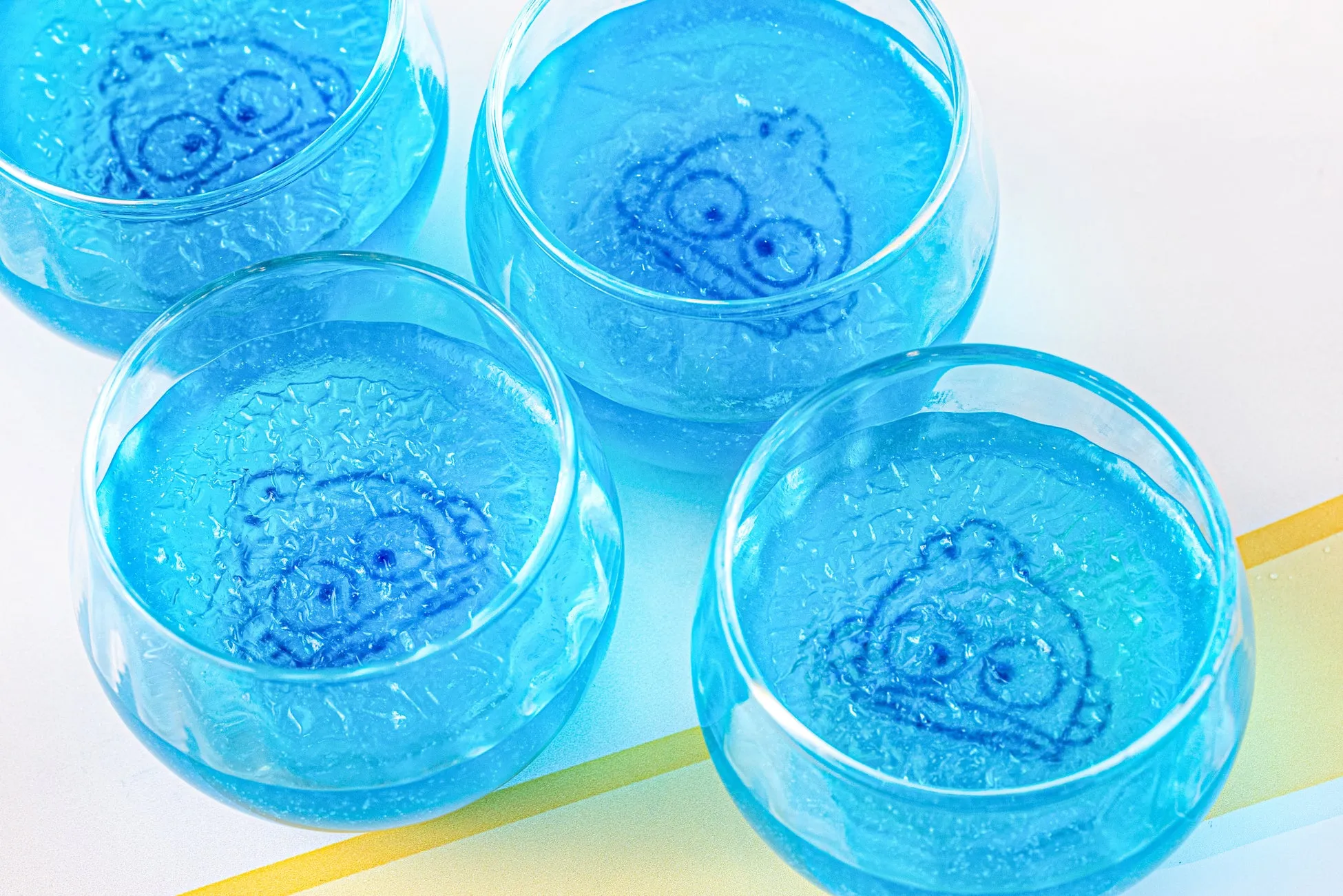 青いゼリーのようなものがグラスに入っており、それぞれにキャラクターが描かれている。