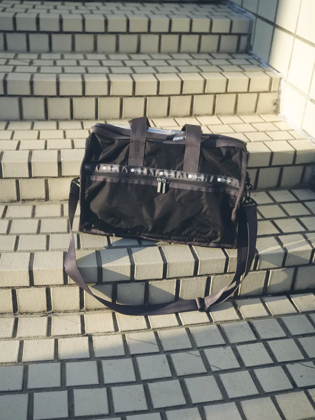 LeSportsac バッグ、階段に置かれた黒いバッグ