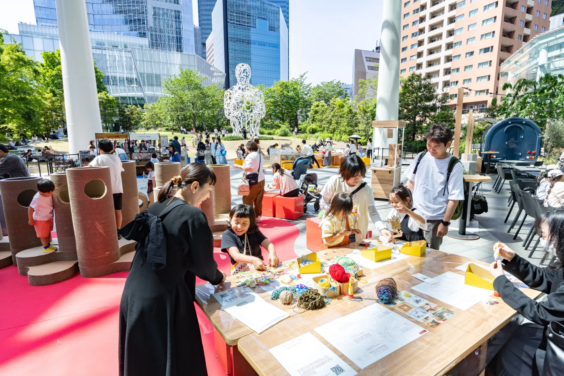 公園で工作を楽しむ子供たちと賑やかな人々