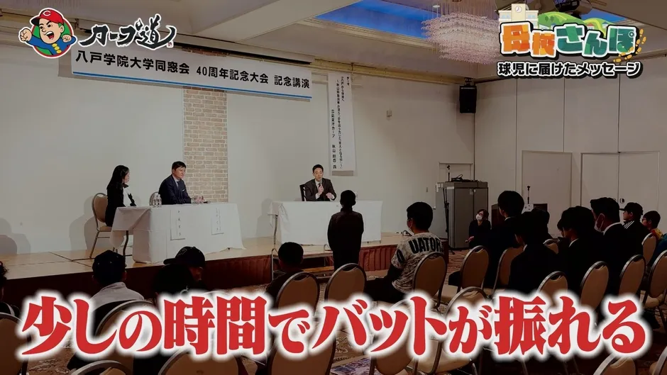 講演会で話す人々とそれを見ている人々の写真。