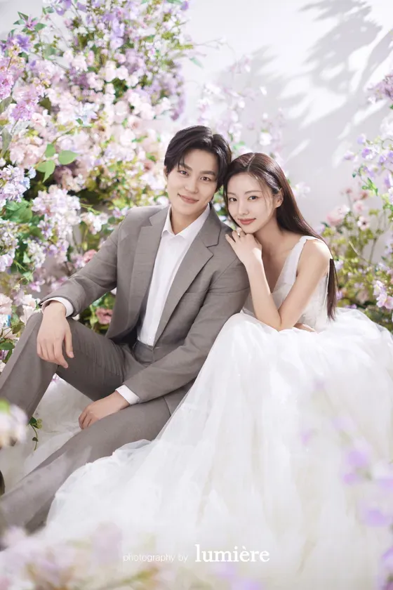 花々に囲まれたウェディングフォトを撮るカップル