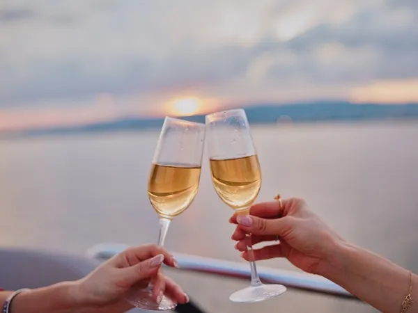 夕暮れの海を背景にシャンパンで乾杯する様子