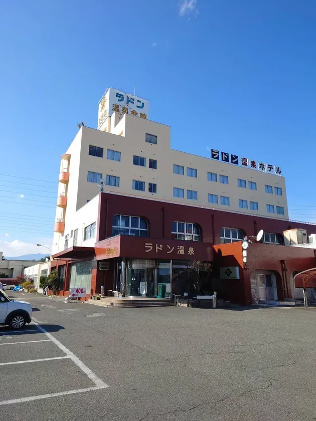 青空の下、温泉会館の建物の写真です。