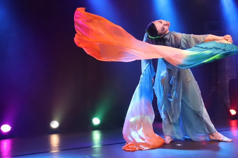 舞台でカラフルな布を使い踊る女性