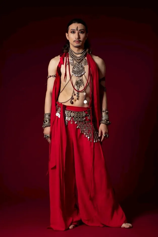 赤い衣装でポーズをとる男性ダンサー