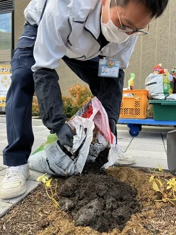 土に肥料を撒いている作業員