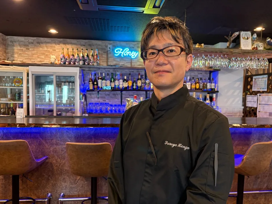 バーカウンターに立つ店主の古屋さん