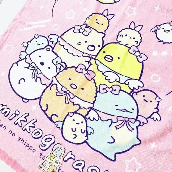 ピンク色のタオルにアイドル姿のすみっコぐらしキャラクターたちが描かれている