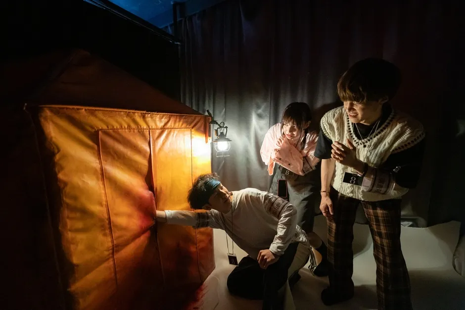 テントの中で謎に挑む参加者