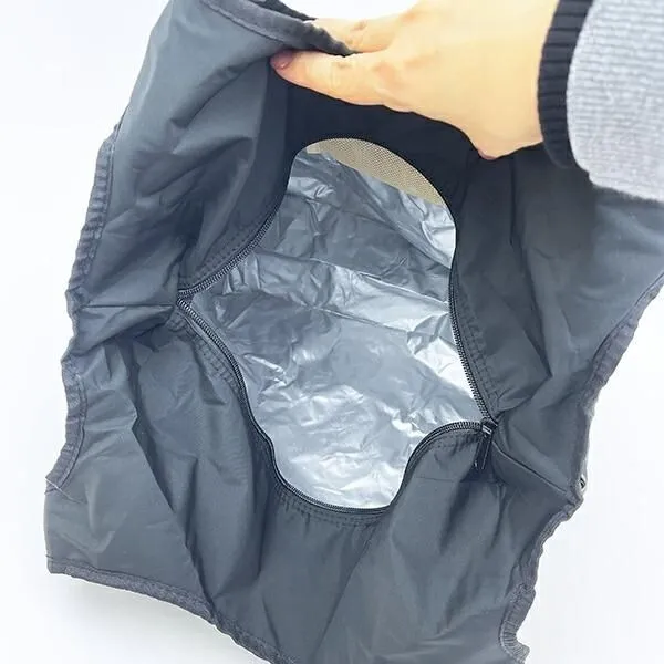 黒いバッグの内側の写真。バッグは開いており、内側は銀色の素材で覆われています。人の手がバッグの上部を掴んでいます。