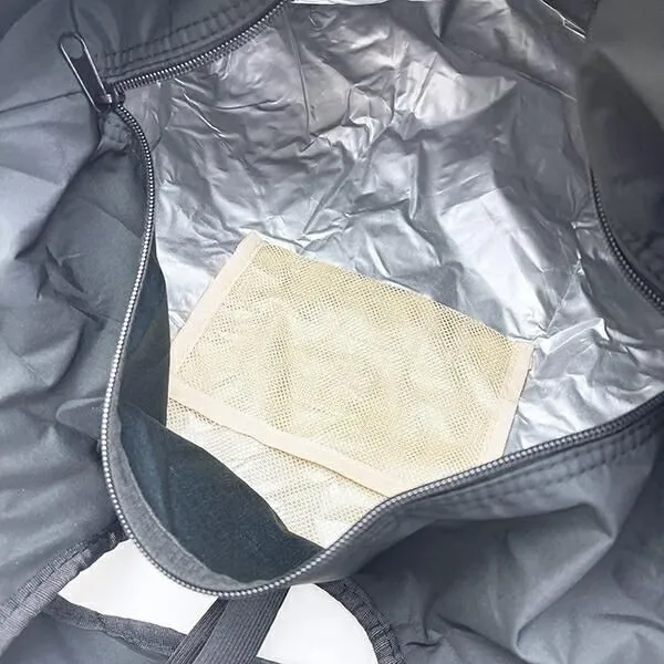 黒いバッグの中身を写した写真。バッグの内側には、シルバーの断熱材のような素材があり、その上に小さなメッシュ状のポーチが置かれている。