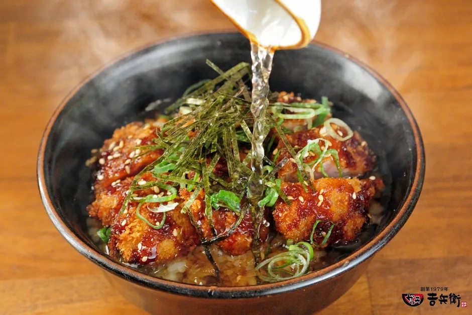 熱々の出汁をかつ丼にかける様子