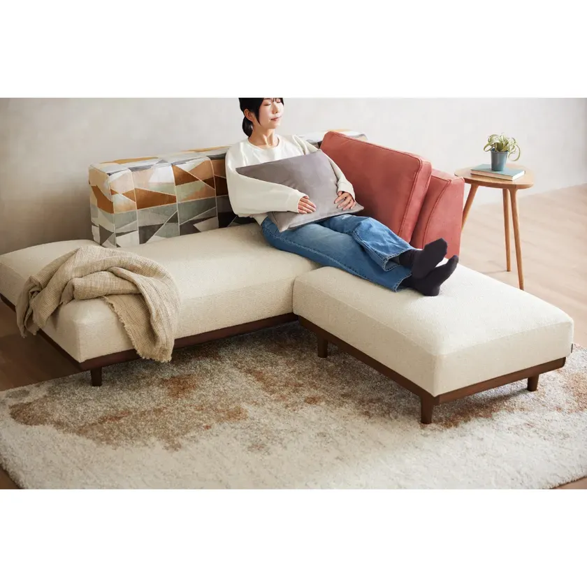 ソファで足を伸ばしてくつろぐ女性