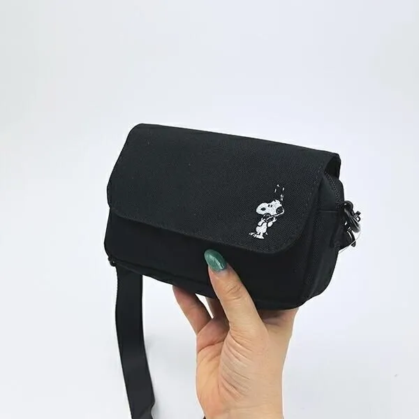 黒いカメラショルダーバッグを手にした様子