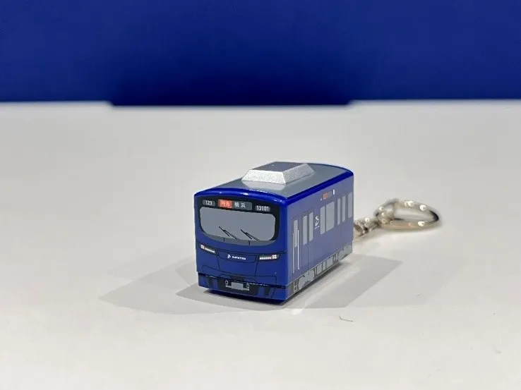 青い電車が線路を走っている様子。