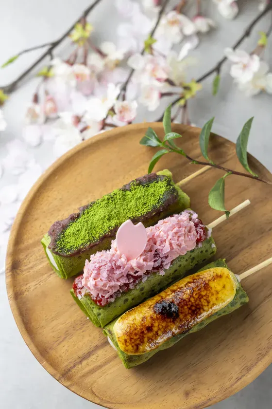 木製の皿の上に、3種類のカラフルなデザートが串に刺さって並んでいる