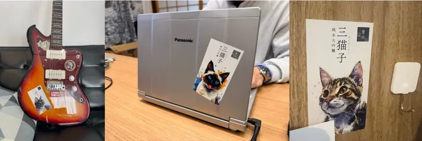 ギター、ノートパソコン、猫のイラストが描かれたカードが写っている画像です。
