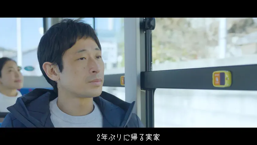 バスの車内で窓の外を眺める男性